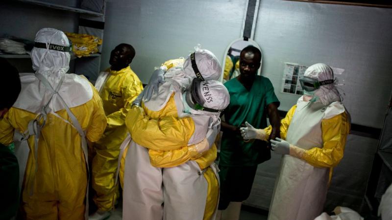 Health workers embrace before heading into an Ebola treatment center in the Congo