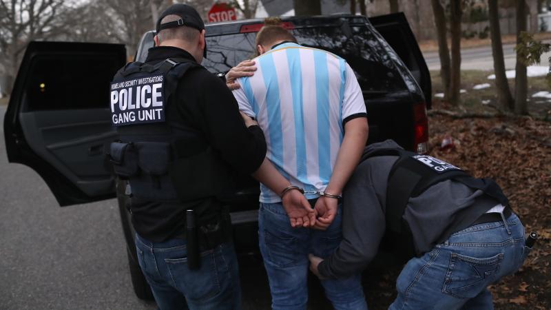 Homeland Security Investigations (HSI) ICE agents frisk a suspected MS-13 gang member and Honduran immigrant after arresting him at his home on March 29, 2018 in Brentwood, New York. 
