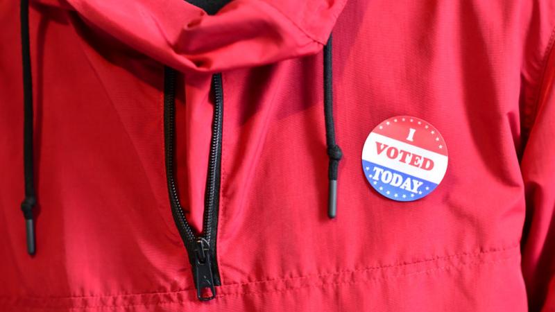 An individual wearing an 'I Voted' sticker.