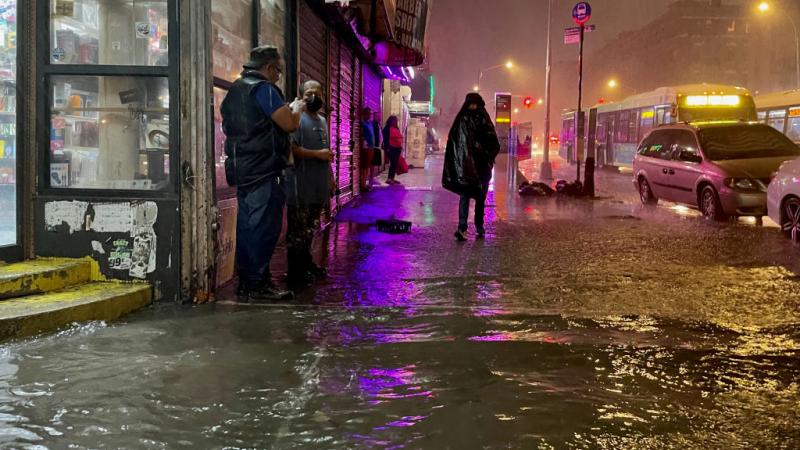 People make their way in rainfall from the remnants of Hurricane Ida on September 1, 2021