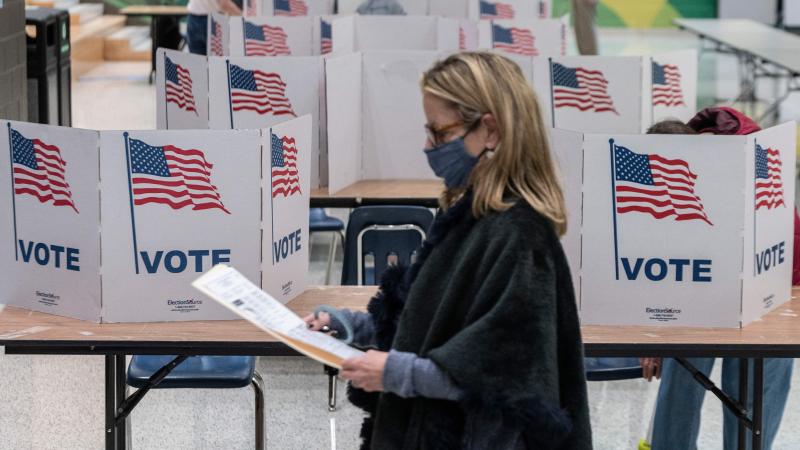 A woman waits to cast her ballot at George Marshall High School, being used as a polling location, on election day in Falls Church, Virginia on November 2, 2021.