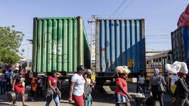 People walk near cargo trucks parked in a market at the Dominican Republic-Haiti border in Dajabon, Dominican Republic on April 7, 2025