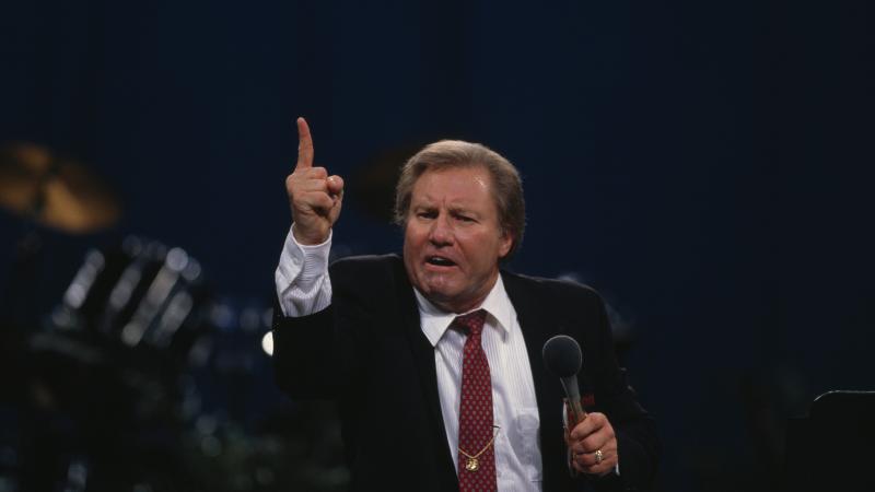 American television evangelist Jimmy Lee Swaggart haranguing his audience on stage.